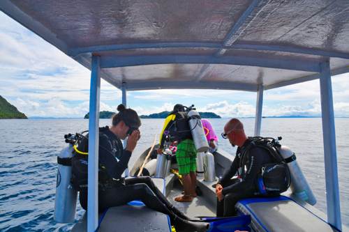 Scuba diver on the boat ready to flip into the water with Cove Eco Resort team